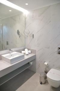 La salle de bains est pourvue d'un lavabo, de toilettes et d'un miroir. dans l'établissement Emerald Hotel, à Kremasti