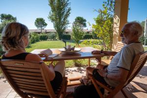 a man and a woman sitting at a table at Residenza Principina in Principina Terra