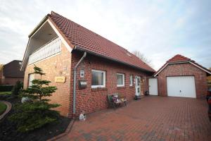 ein rotes Backsteinhaus mit einer Ziegelsteinfahrt in der Unterkunft Ferienwohnung Schilling, 65043 in Moormerland