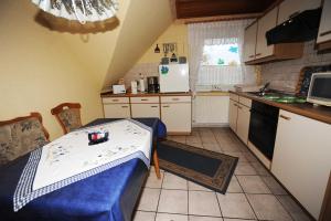 eine kleine Küche mit einem Tisch, einem Tisch und einer Theke in der Unterkunft Ferienwohnung Schilling, 65043 in Moormerland