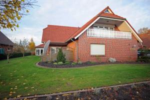 ein Backsteinhaus mit Rasen davor in der Unterkunft Ferienwohnung Schilling, 65043 in Moormerland
