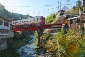 a train on a red bridge over a river at The Railway Hotel Koyasan Pilgrimage Railway - Station Inn - Self Check-in Only in Kudoyama