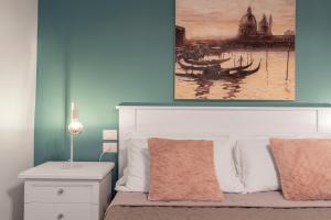 een slaapkamer met een bed met twee schilderijen aan de muur bij Dorsoduro Suite 1241 in Venetië