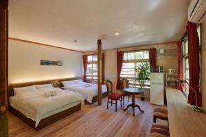 a bedroom with two beds and a table and a refrigerator at The Railway Hotel Koyasan Pilgrimage Railway - Station Inn - Self Check-in Only in Kudoyama