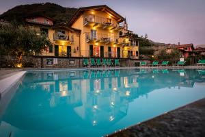 a large swimming pool in front of a house at La Collina degli Ulivi in Vercana
