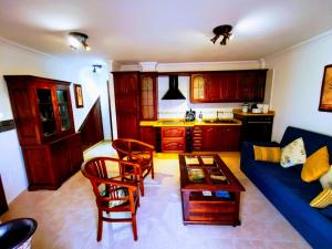 uma sala de estar com um sofá azul e uma mesa em Apartamento Verode em Puerto Naos