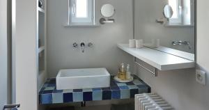 a white bathroom with a sink and a mirror at Sint Jacobs in Bruges