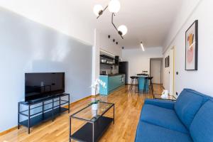 a living room with a blue couch and a tv at Luxury Penthouse on Akadimias with 2 Bed & 2 Bath in Athens