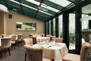 a dining room with tables and chairs and windows at Wyndham Hannover Atrium in Hannover