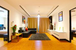 een woonkamer met een bank en een bed bij Serena Sathorn Suites in Bangkok