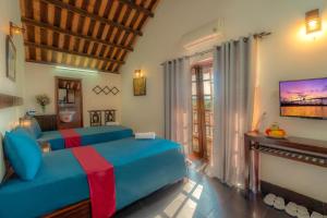 a bedroom with a blue bed in a room at Calm House Hotel Hoi An 1 in Hoi An