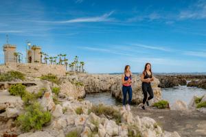 two women walking in the water on the beach at Piccadilly Rooms Restaurant and Beach in Santa Maria al Bagno