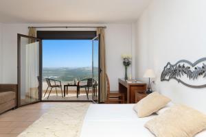 sypialnia z łóżkiem oraz balkon ze stołem w obiekcie Los Castillarejos Apartamentos Rurales w mieście Luque