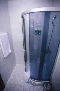 a shower with a glass door in a bathroom at Aktau Hotel in Aktau