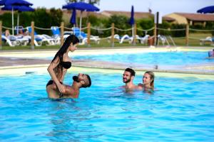 a group of people in a swimming pool at Residenza Principina in Principina Terra