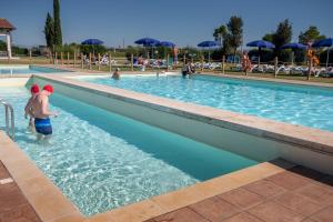 a young boy standing in a swimming pool at Residenza Principina in Principina Terra