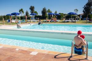 two men sitting in a pool at a resort at Residenza Principina in Principina Terra