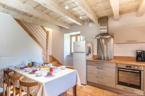 une cuisine avec une table et un chiffon de table blanc dans l'établissement GÎTE DU PORCHE, à Saint-Jean-de-la-Porte