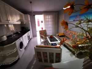 a kitchen and living room with a couch and a table at Apartamento Candil in Puerto Naos