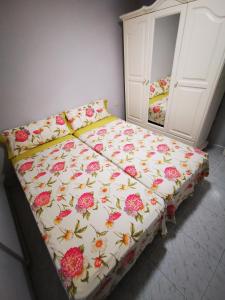 - un lit avec une couette à fleurs dans une chambre dans l'établissement Apartamento Candil, à Puerto Naos