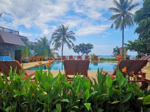 a resort with a pool and chairs and palm trees at Kao Tao Villa Beach Resort-Hua Hin in Khao Tao