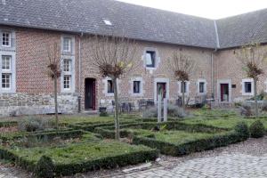 een bakstenen gebouw met een tuin ervoor bij Apartments Cour d'Aix in Richelle