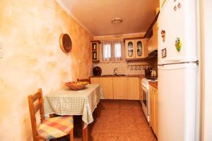 a kitchen with a table and a white refrigerator at Traditional Stone Home with view in Throfárion