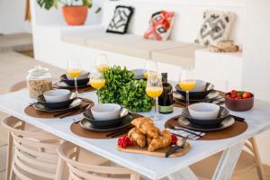 a white table with food and glasses of wine at Sea'Ya Thoughtful Stays - Villas in Cascais