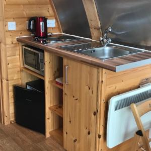 a kitchen with a sink and a microwave at Loch Shin Glamping Pods in Lairg