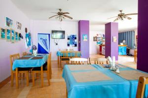 a dining room with blue tables and chairs and purple walls at Klong Muang Sunset House in Klong Muang Beach