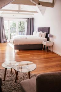 a bedroom with a bed and a coffee table at De Haas Living @ Die Laan 40 in Stellenbosch