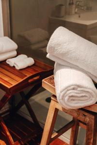 a stack of towels sitting on a stool in a bathroom at De Haas Living @ Die Laan 40 in Stellenbosch