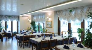 un comedor con mesas y sillas en un restaurante en Stella d'Oro, en Marano Lagunare