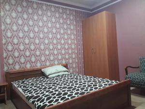 мини-отель "Алатау" في بافلودار: غرفة نوم صغيرة بها سرير وكرسي
