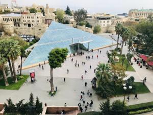 a group of people walking around a building with a glass pyramid at Liman Hotel Baku in Baku