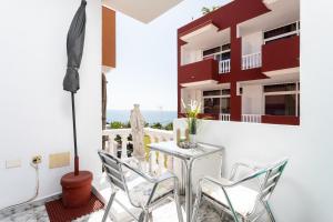 a balcony with a table and chairs and the ocean at Casa Alcala in Alcalá