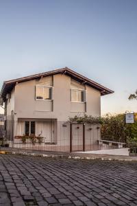 uma casa com uma cerca em frente em Pousada Don Marini em Bento Gonçalves