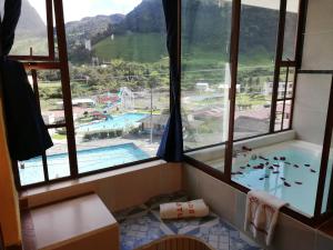 a bathroom with a view of a swimming pool at Hotel COTURPA in Papallacta