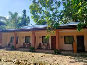 a house with tables and chairs in front of it at Two Season Tourist Inn in San Vicente +10 photos