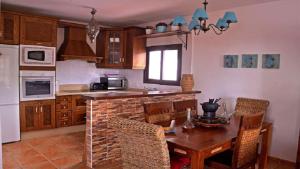 eine Küche mit einem Tisch und Stühlen sowie eine Küche mit einem Herd in der Unterkunft Los Espejos de Frigiliana in Frigiliana