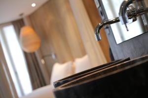巴黎的住宿－喜登酒店，沙发旁带水龙头的浴室水槽