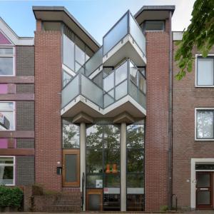 une maison avec un escalier en métal sur le côté d'un bâtiment en briques dans l'établissement Bed & Ontbijt Haddock, à Almere