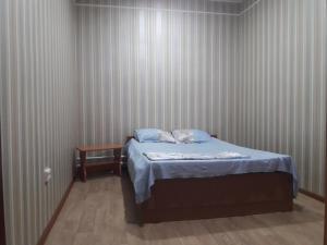 мини-отель "Алатау" في بافلودار: غرفة نوم صغيرة مع سرير وطاولة