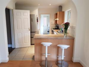 a kitchen with a counter and two bar stools at Home2Home Meadow Close in East Kilbride