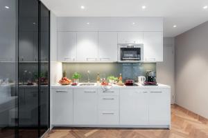 a white kitchen with a sink and a microwave at VISIONAPARTMENTS Bellariastrasse - contactless check-in in Zurich