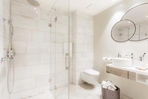 a bathroom with a shower and a toilet and a sink at VISIONAPARTMENTS Bellariastrasse - self check-in in Zurich