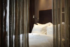 a bedroom with a bed with white sheets and pillows at Hidden Hotel in Paris