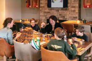 eine Gruppe von Menschen, die an einem Tisch in einem Restaurant sitzen in der Unterkunft TopParken – Résidence Lichtenvoorde in Lichtenvoorde