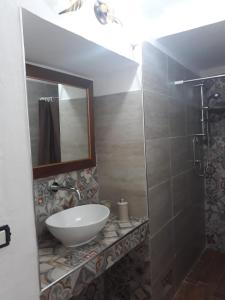 y baño con lavabo, espejo y ducha. en Il Vallone, en Crispiano