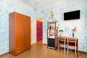 a dining room with a table and a tv on the wall at Lia Rooms 4 in La Spezia